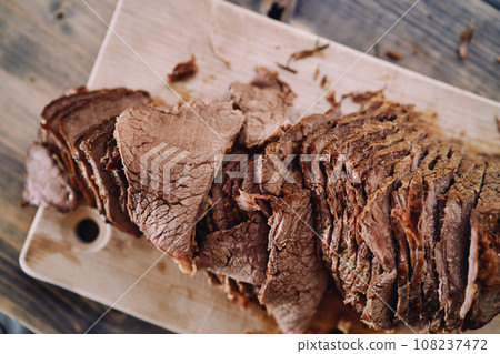Slices of juicy roast beef lie in a row on a cutting board Slices of juicy roast beef lie in a row on a cutting board 108237472
