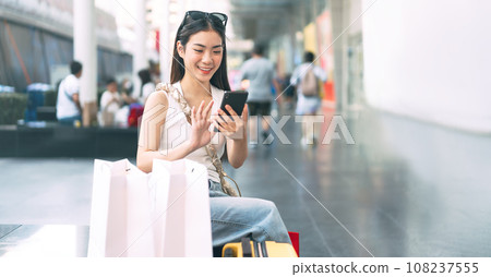 Asian woman city lifestyles using smartphone and shopping at department store 108237555