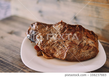 Juicy fried tenderloin with spices and vegetables lies on a plate Juicy fried tenderloin with spices and vegetables lies on a plate 108237883