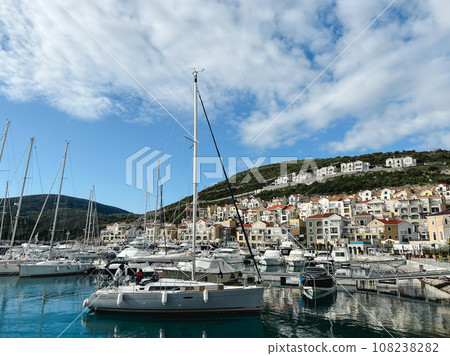 Lustica bay marina with moored yachts and colorful houses at the foot of the mountains. Montenegro 108238282