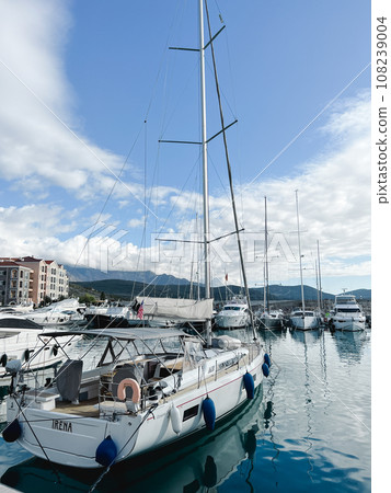 Sailing yachts stand at the pier against the backdrop of a mountain range Sailing yachts stand at the pier against the backdrop of a mountain range 108239004