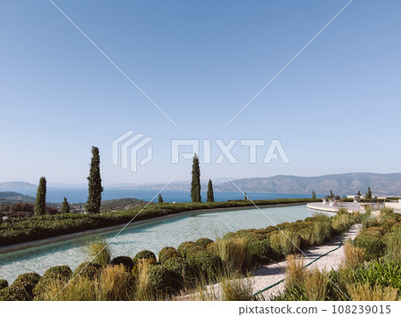 Long pool over the sea against the backdrop of mountains. Hotel Amanzoe, Greece Long pool over the sea against the backdrop of mountains. Hotel Amanzoe, Greece 108239015