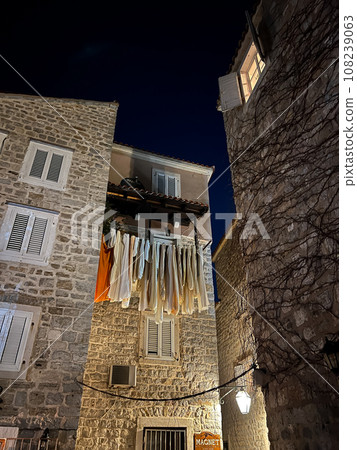 Laundry dries on clothesline between ancient stone houses 108239063