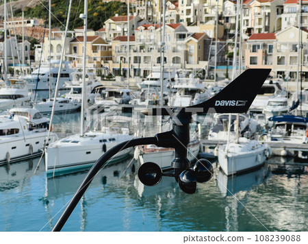 Modern anemometer with a weathervane near the marina near the resort town 108239088