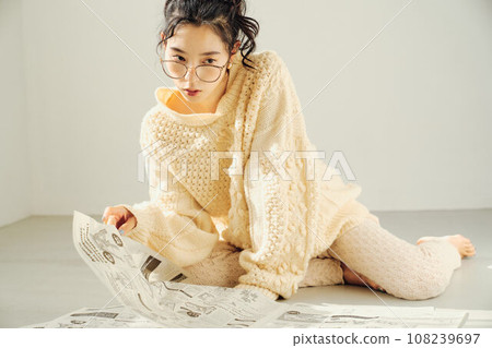 Woman sitting on the floor and reading a newspaper 108239697