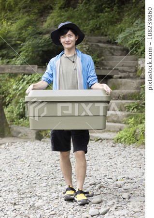Young man carrying trunk cargo - camping image 108239860
