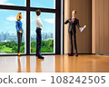 A young couple receives an explanation of their room from a real estate agent 108242505
