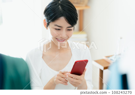 在家裡經營智能手機的女人 108243270