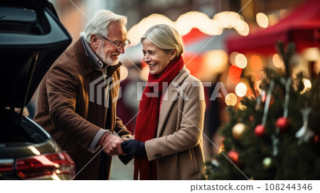 sale, winter holidays and people concept - happy senior couple with gift bags at christmas market 108244346