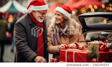 sale, winter holidays and people concept - happy senior couple with gift bags at christmas market 108244347