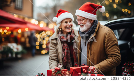 happy senior couple with gift bags at city christmas market happy senior couple with gift bags at city christmas market 108244355