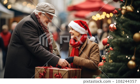 happy senior couple with gift bags at city christmas market 108244357
