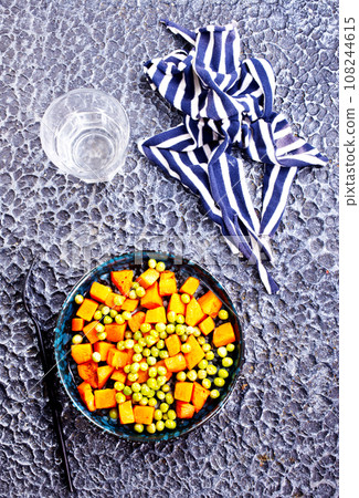 Peas and carrots in a black salad bowl 108244615
