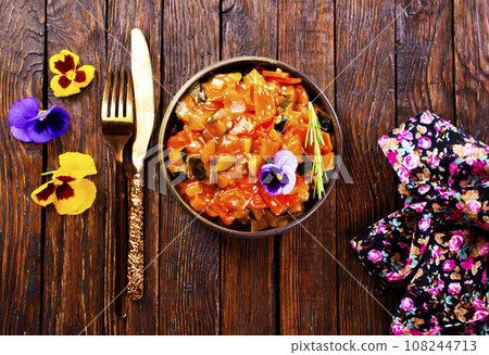 vegetable stew, eggplant, onion, zucchini with tomato sauce, garlic and herbs in a baking dish on a wooden table, landscape view from above, close-up, flat lay, free space 108244713
