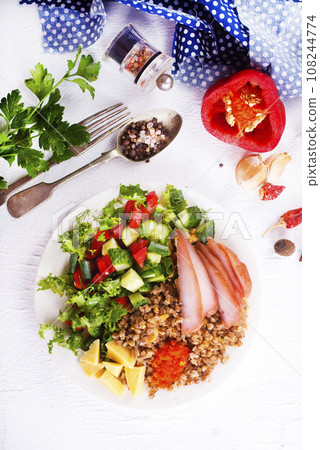 A plate of buckwheat with meat, salad , cheese on white backgrond 108244774