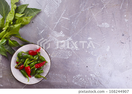 Red and green Chillies on white plate Red and green Chillies on white plate 108244907