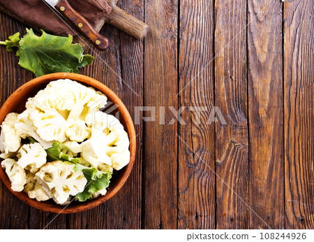 Fresh organic cauliflower cut into small pieces in ceramic bowl on wooden background Fresh organic cauliflower cut into small pieces in ceramic bowl on wooden background 108244926