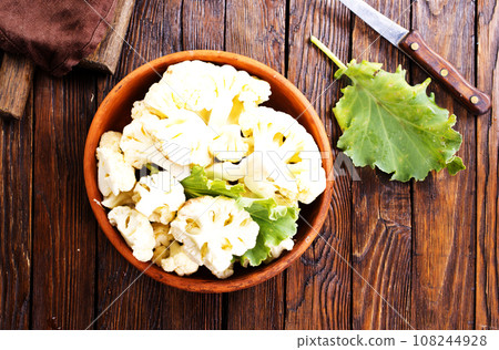 Fresh organic cauliflower cut into small pieces in ceramic bowl on wooden background 108244928
