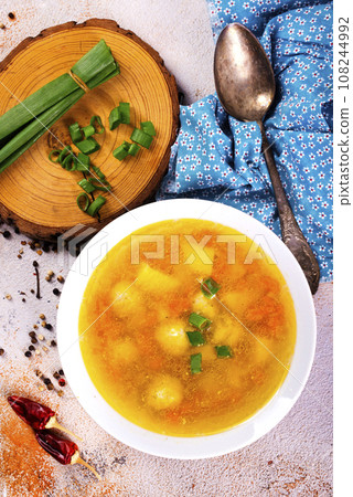 Pea soup with pieces of bacon and parsley in a bowl on white background. Selective focus 108244992