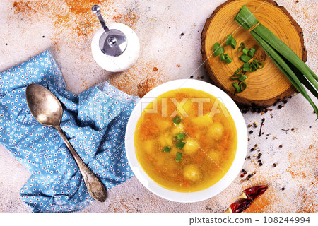 Pea soup with pieces of bacon and parsley in a bowl on white background. Selective focus 108244994