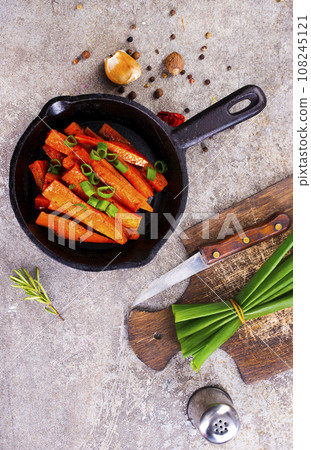 Fried carrots with green herbs in baking tray, close up 108245121