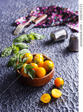 Fresh ripe yellow tomatoes on dark table outdoors, closeup Fresh ripe yellow tomatoes on dark table outdoors, closeup 108245152