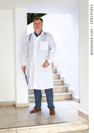 Portrait of a doctor, adult man in a medical gown, full length 108245852