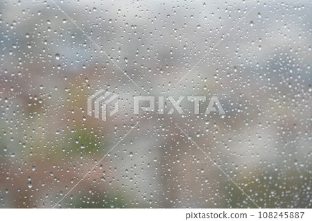 rain drops on window over buildings 108245887