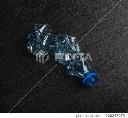 Blue Empty Plastic Bottle on Black Background, Crumpled Plastic Bottle, Global Pollution Concept 108247073