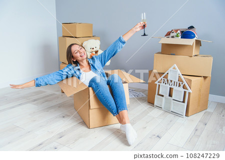 Pretty beautiful girl raised her hands up while moving to the new home. Pretty beautiful girl raised her hands up while moving to the new home. 108247229