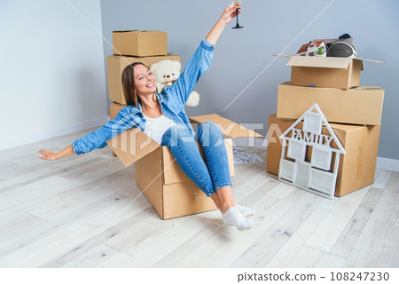 Pretty beautiful girl raised her hands up while moving to the new home. Pretty beautiful girl raised her hands up while moving to the new home. 108247230