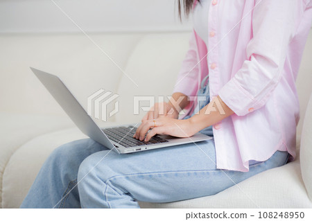 Closeup hands business woman work from home with laptop computer online to internet on sofa. Closeup hands business woman work from home with laptop computer online to internet on sofa. 108248950