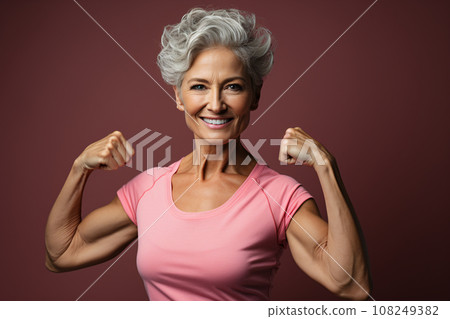 Beautiful cheerful middle aged senior woman with healthy lifestyle, smiling and flexing arm muscles on pink background, health and wellness for aging society concept. Generative AI 108249382
