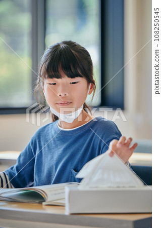 Elementary school girl picking up tissue paper 108250545