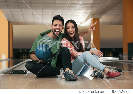 Happy young couple with ball in bowling club 108252654