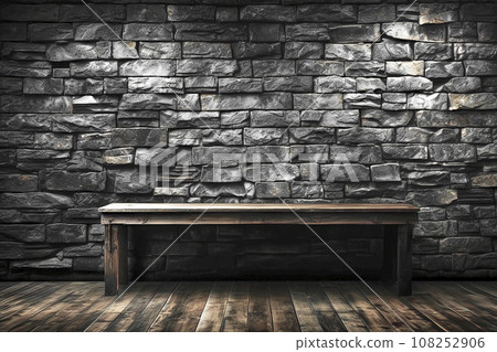 Simple Old Wooden Bench on a Wooden Plank Floor in Front of a Wall of Rough Hewn Basalt Stones Laid in a Brick-like Pattern 108252906