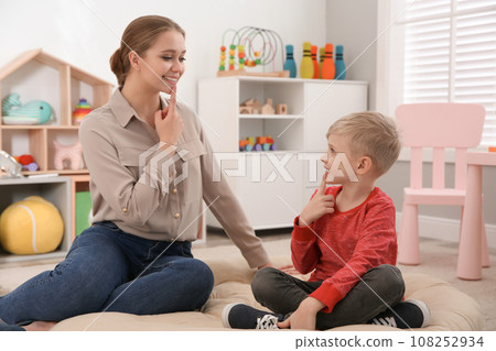 Speech therapist working with little boy in office 108252934
