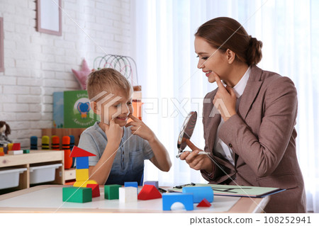 Speech therapist working with little boy in office 108252941