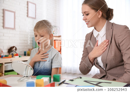 Speech therapist working with little boy in office 108252943