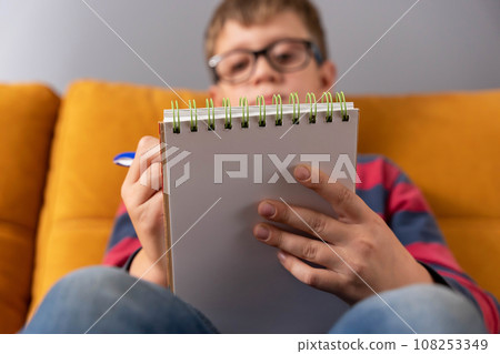 boy concentrating on drawing in his notebook in a moment of creative inspiration 108253349
