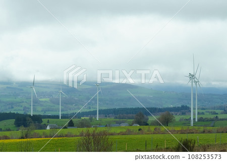 Wind turbines on the background of the field, mountains and clouds Wind turbines on the background of the field, mountains and clouds 108253573