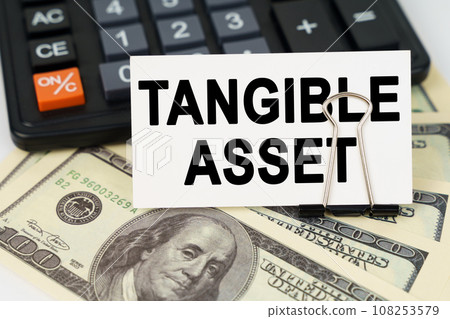 On the dollars there is a calculator and a business card with the inscription - tangible asset 108253579