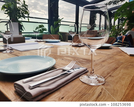 Empty glass, plate, fork and knife in restaurant Empty glass, plate, fork and knife in restaurant 108253698