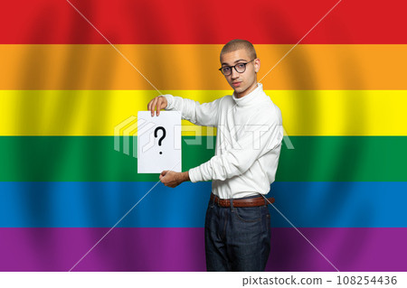 Guy in glasses holding white paper board  with question mark on in in his hands  108254436