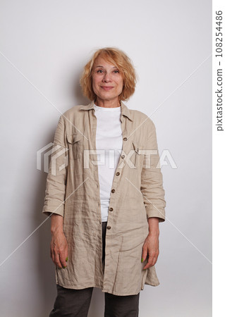 Happy stylish senior woman smiling and standing on white background 108254486