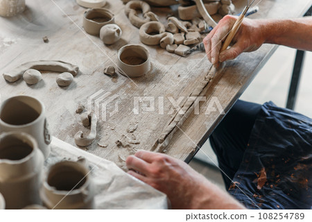 Male potter hands working with clay. Art work concept. Male potter hands working with clay. Art work concept. 108254789