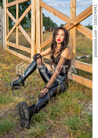 Beautiful young caucasian woman sitting at the ranch gate. Beautiful young caucasian woman sitting at the ranch gate. 108254941