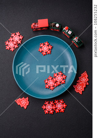 Ceramic round plate decorated with festive elements on the Christmas table 108255232