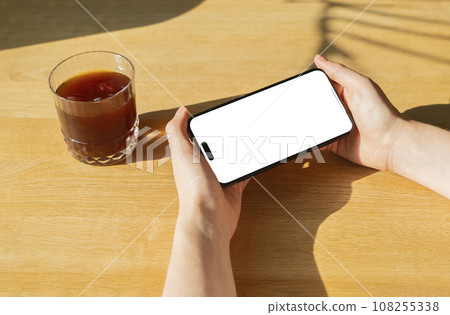 Berlin, Germany October 20 2023 Hands holding mobile phone screen mockup, horizontal smartphone 108255338