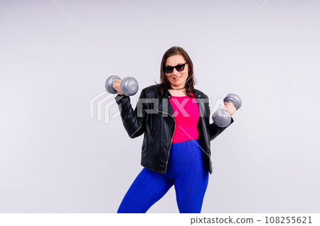 Sporty model with curvy figure with dumbbells. Dynamic movement. Motivation and healthy lifestyle Sporty model with curvy figure with dumbbells. Dynamic movement. Motivation and healthy lifestyle 108255621